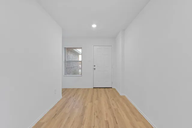 a view of a room with wooden floor and white walls