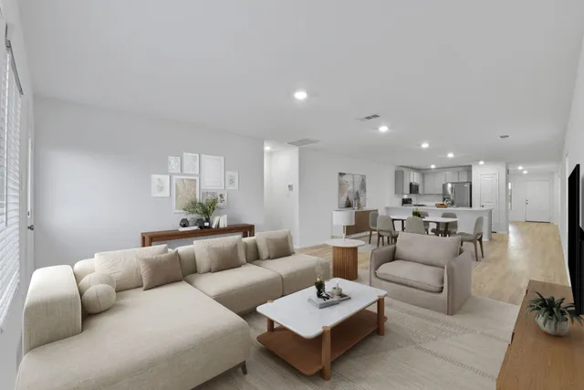 a living room with furniture and a view of kitchen