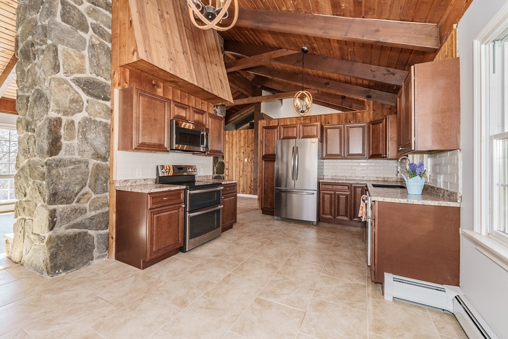 78 Pine Ridge Road Montgomery, MA 01085 - Photo 11 of 42 a kitchen with a refrigerator and a stove top oven