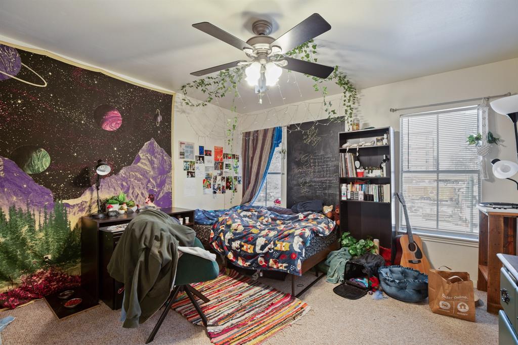 2529 Rio Grande Street, Unit 7 Austin, TX 78705 - Photo 8 of 13 a bedroom with lots of furniture and a chandelier