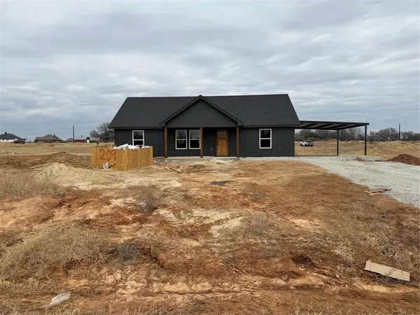 a front view of house with yard and ocean