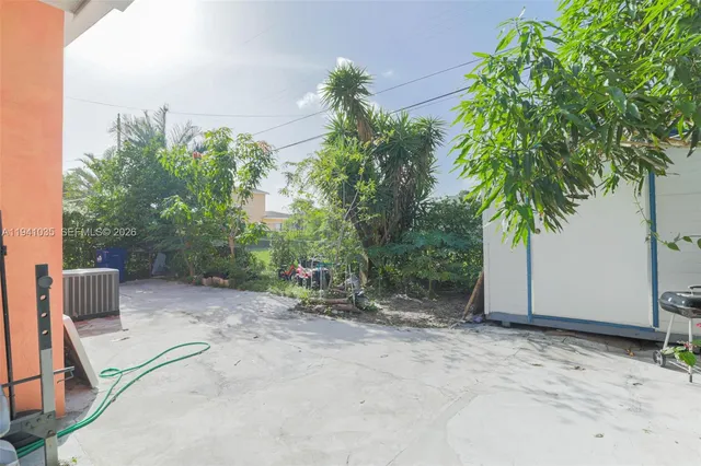 a view of backyard with a patio and a tub
