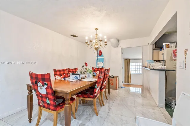 a dining room filled chandelier and wooden furniture