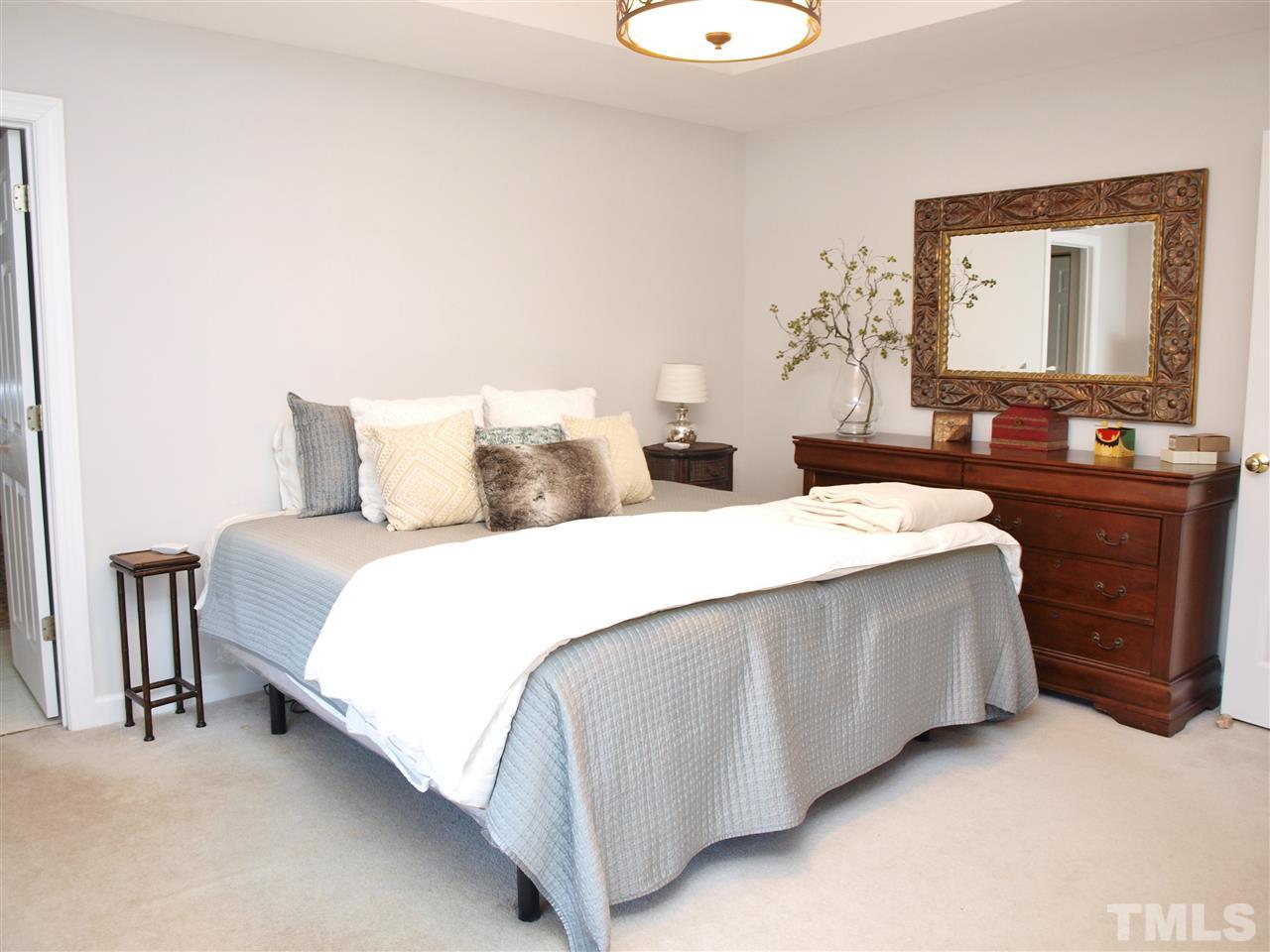 12009 Shavenrock Place Raleigh, NC 27613 - Photo 16 of 30 a spacious bedroom with a bed and a dresser