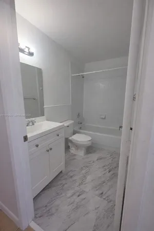 a view of bathroom with double vanity sink a toilet and a mirror
