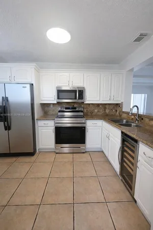 a kitchen with stainless steel appliances granite countertop a stove a sink and a refrigerator