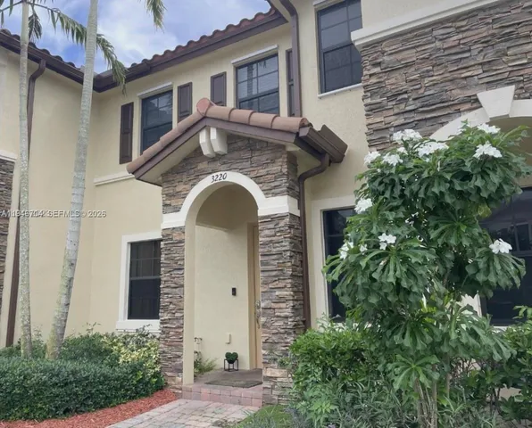 a front view of a house with plants