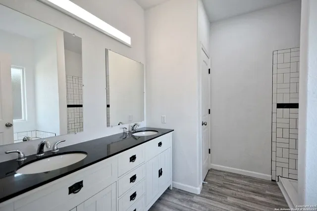 a bathroom with a granite countertop sink and a mirror