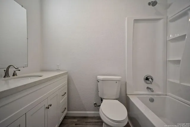 a bathroom with a granite countertop toilet tub and vanity