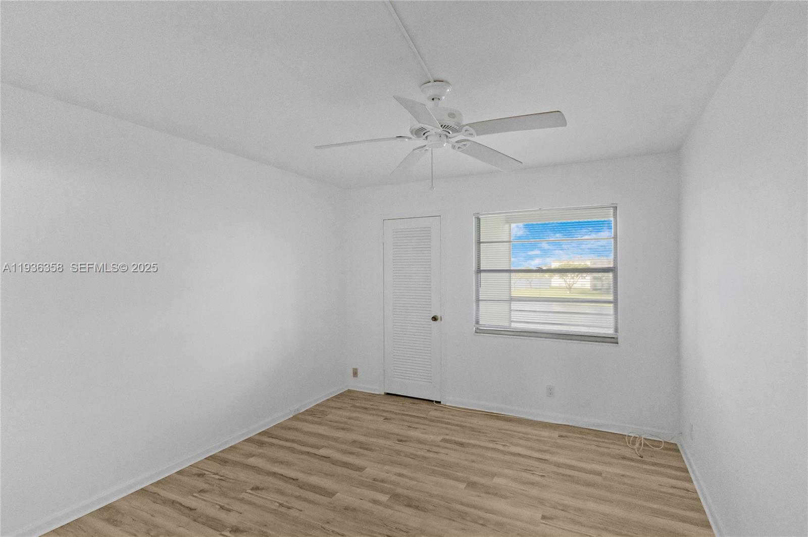 3030 Lincoln B, Unit 3030 Boca Raton, FL 33434 - Photo 12 of 25 a view of empty room with wooden floor and fan