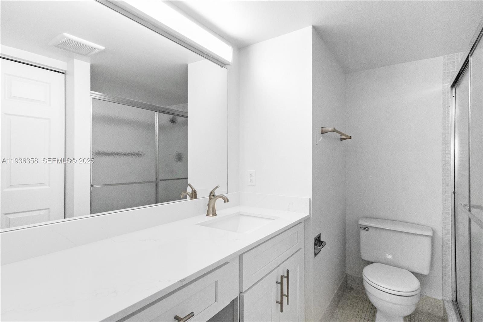 3030 Lincoln B, Unit 3030 Boca Raton, FL 33434 - Photo 18 of 25 a bathroom with a sink toilet vanity and shower