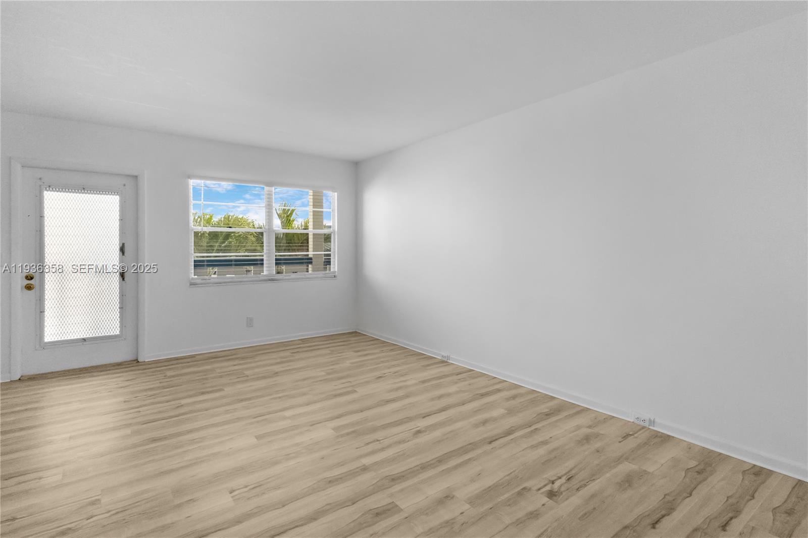 3030 Lincoln B, Unit 3030 Boca Raton, FL 33434 - Photo 4 of 25 an empty room with wooden floor and windows