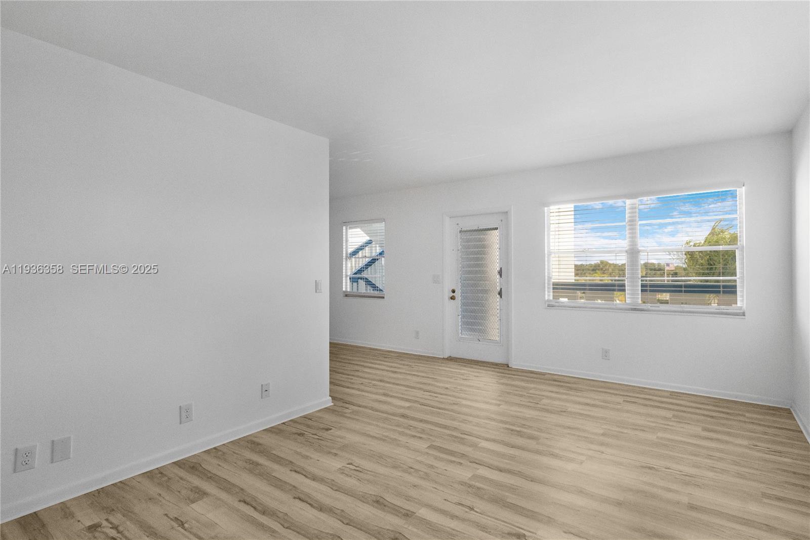 3030 Lincoln B, Unit 3030 Boca Raton, FL 33434 - Photo 5 of 25 an empty room with wooden floor and windows