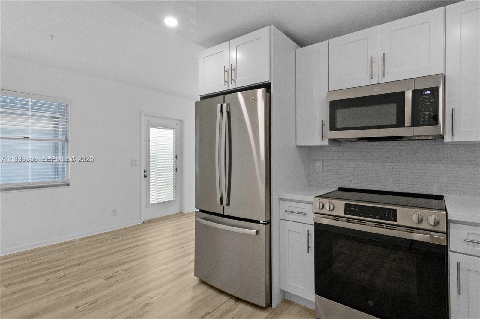 3030 Lincoln B, Unit 3030 Boca Raton, FL 33434 - Photo 8 of 25 a kitchen with stainless steel appliances a refrigerator microwave and sink