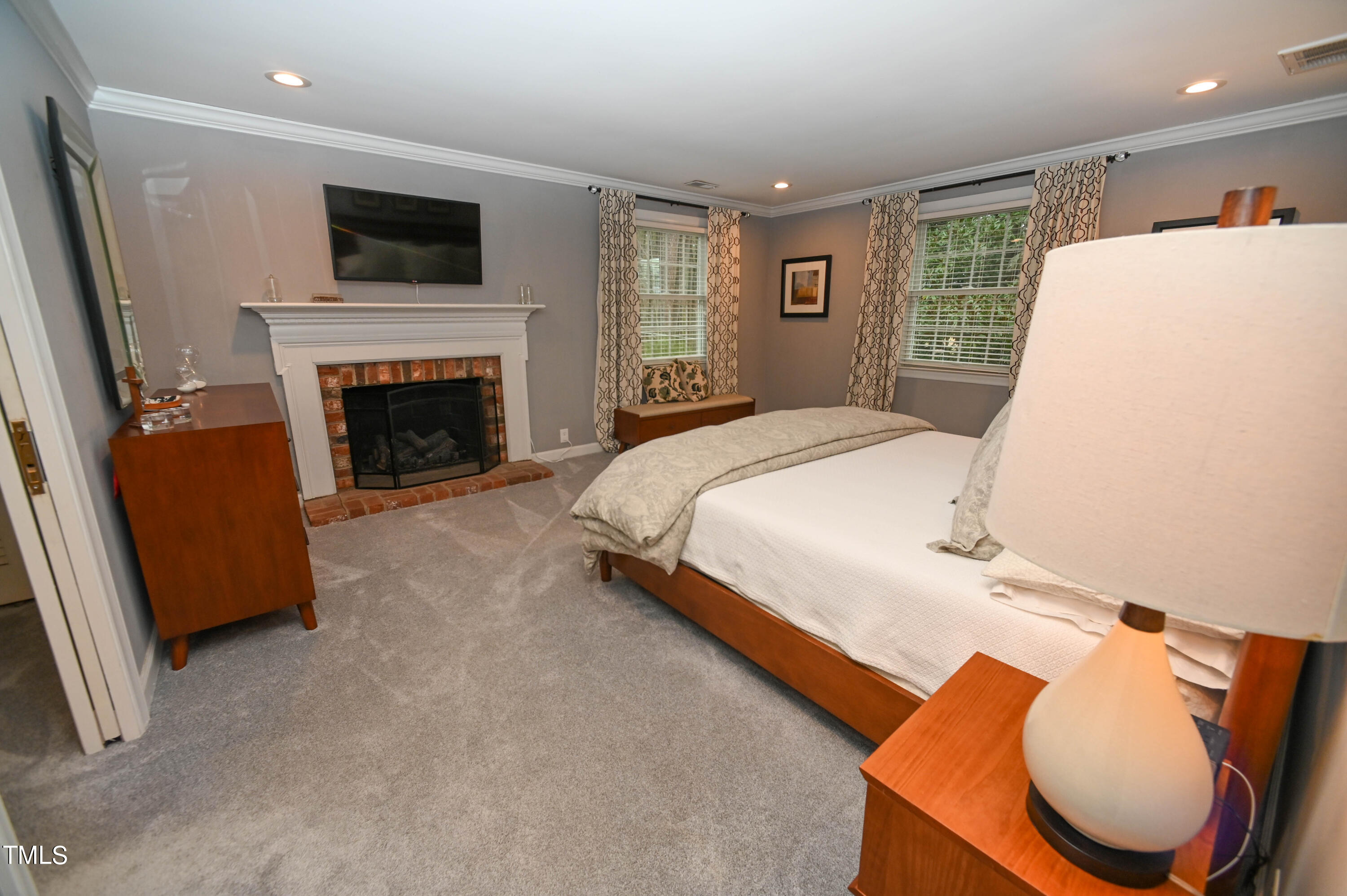 5313 Alpine Drive Raleigh, NC 27609 - Photo 13 of 20 a spacious bedroom with a bed and a flat screen tv