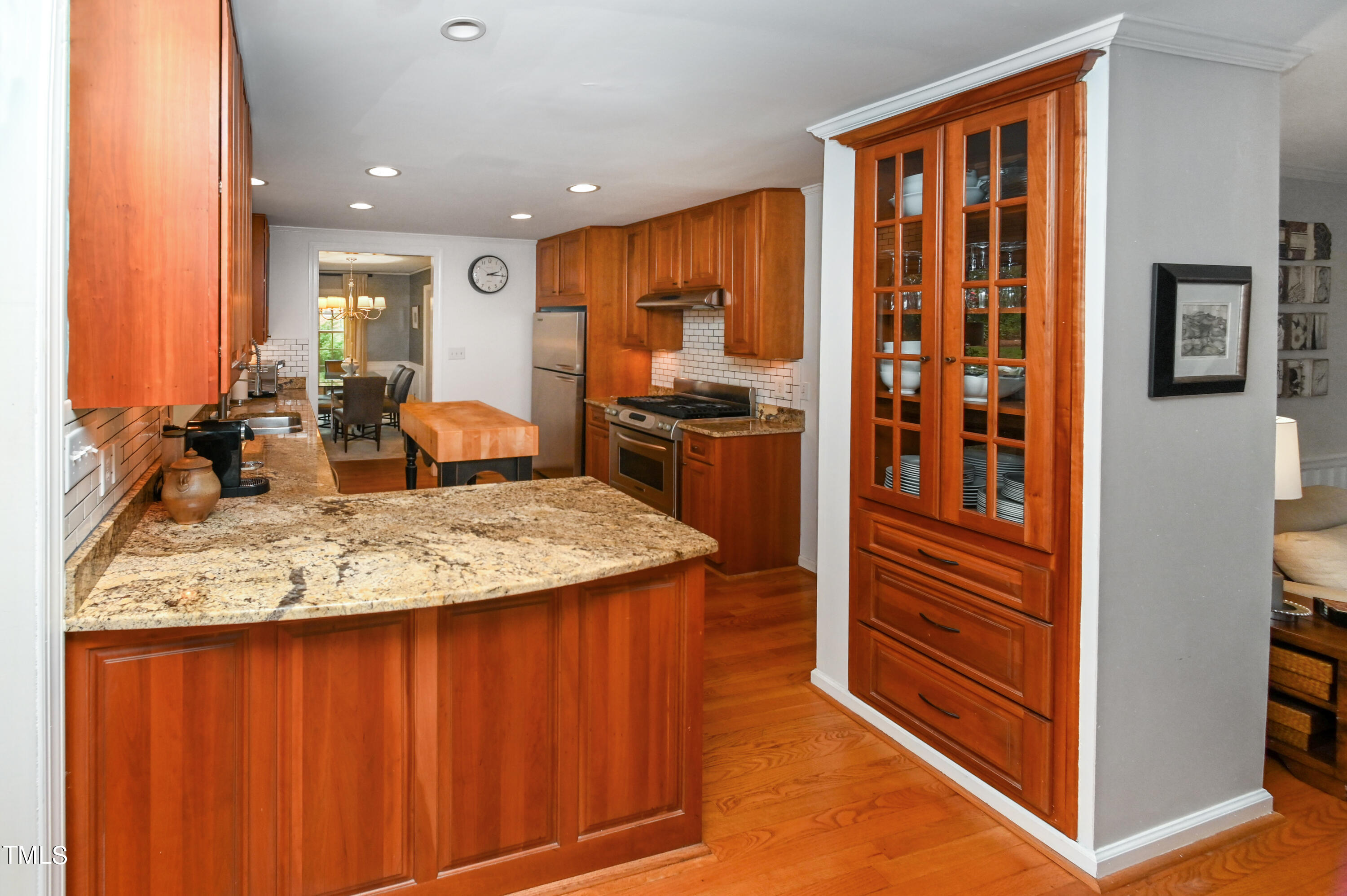 5313 Alpine Drive Raleigh, NC 27609 - Photo 9 of 20 a kitchen with kitchen island granite countertop wooden cabinets and stainless steel appliances
