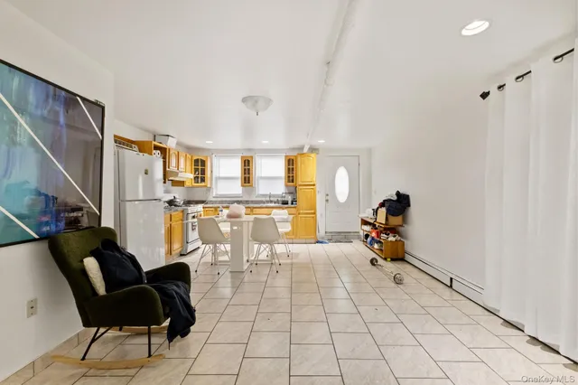 a living room with chairs and kitchen view