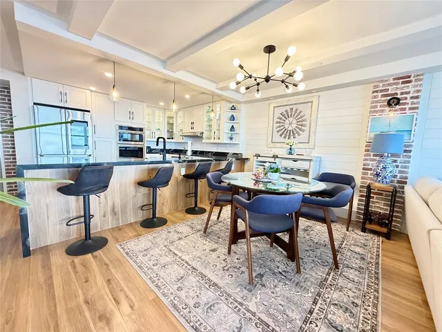 a view of a dining room with furniture a chandelier and wooden floor