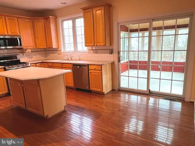 a kitchen with stainless steel appliances granite countertop a stove a sink and a large window