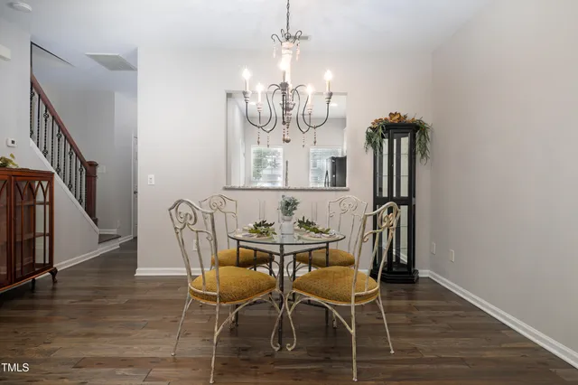 a view of a dining room with furniture a chandelier and wooden floor