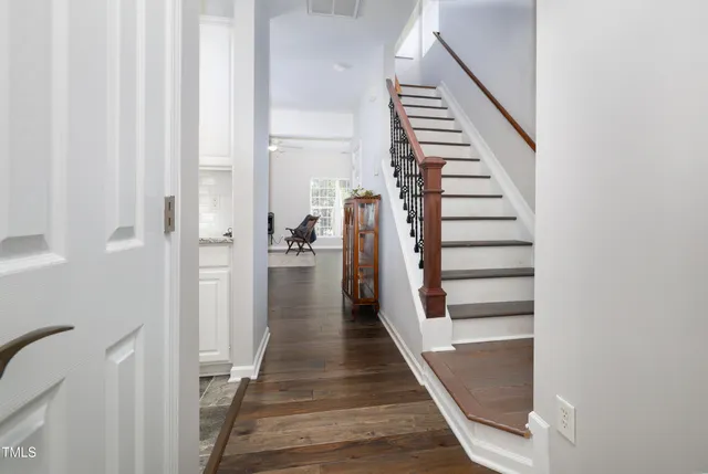 a view of a hallway with wooden floor and entryway