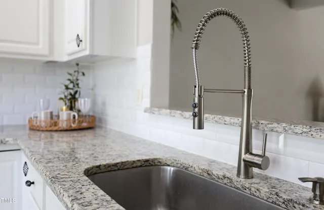 a kitchen with granite countertop a sink a stove and a granite counter top
