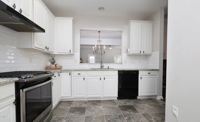 a kitchen with stainless steel appliances granite countertop a stove a sink and a granite counter tops