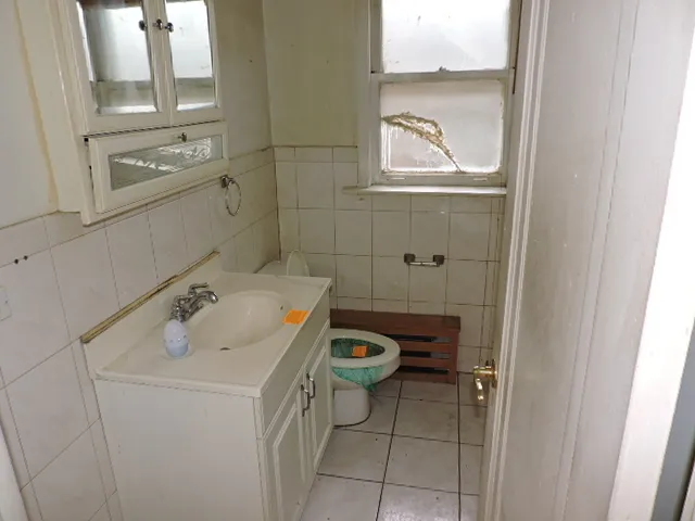 a bathroom with a sink and mirror with toilet