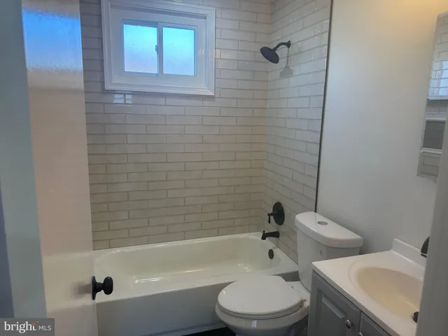 a white toilet sitting next to a bath tub