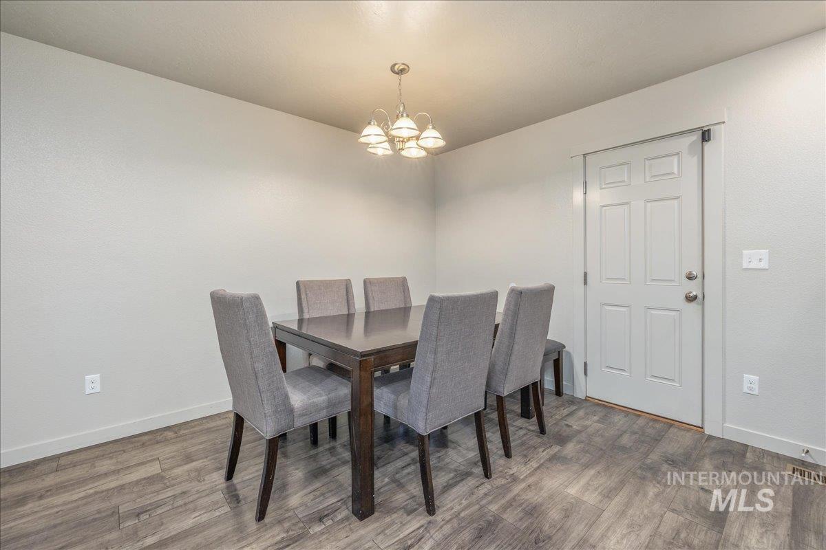 661 North Scotney Avenue Meridian, ID 83642 - Photo 10 of 22 Dining room featuring light wood-style flooring and a chandelier