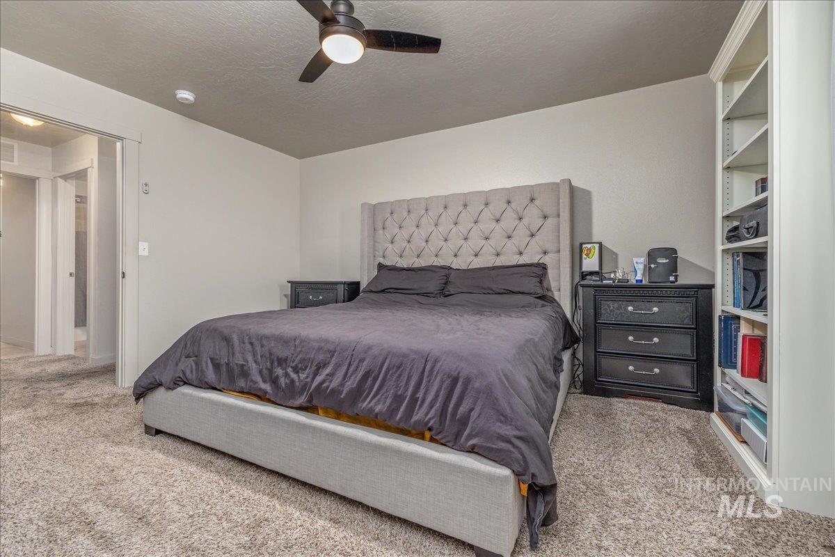 661 North Scotney Avenue Meridian, ID 83642 - Photo 12 of 22 Bedroom featuring light carpet, a textured ceiling, and ceiling fan