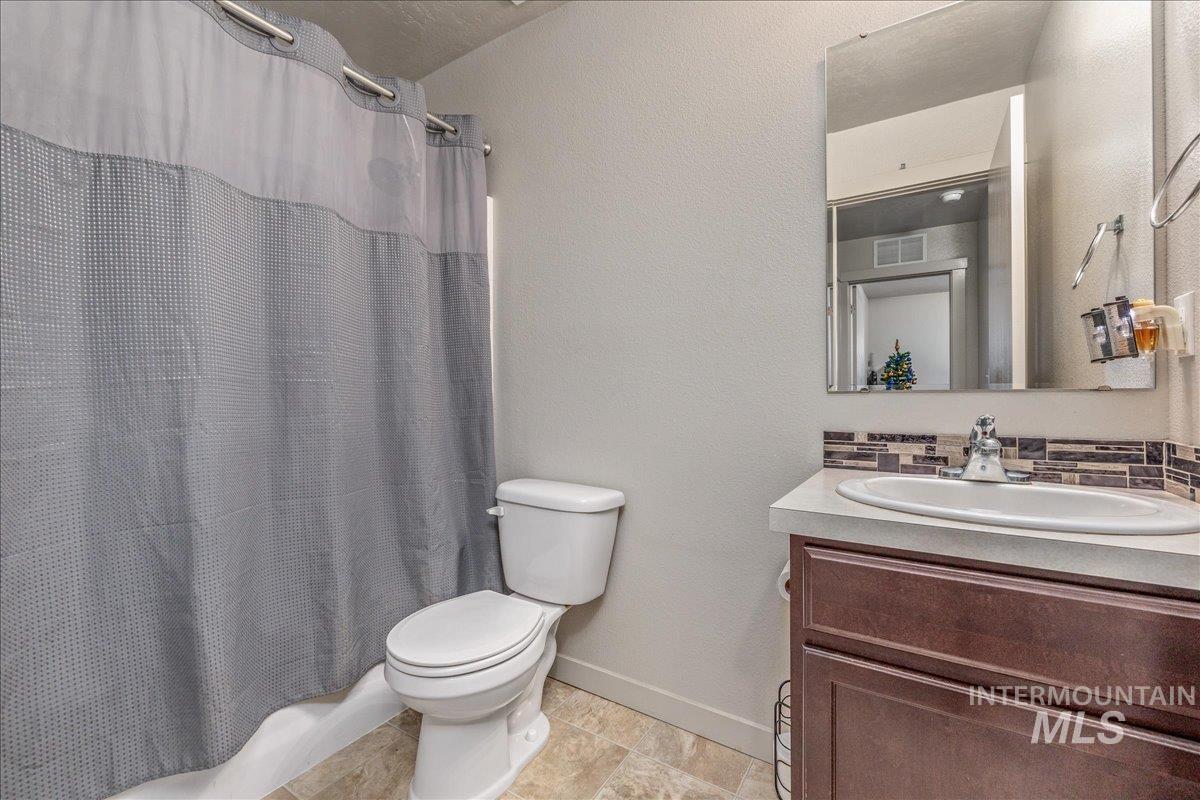 661 North Scotney Avenue Meridian, ID 83642 - Photo 16 of 22 Bathroom with vanity, a textured wall, and backsplash