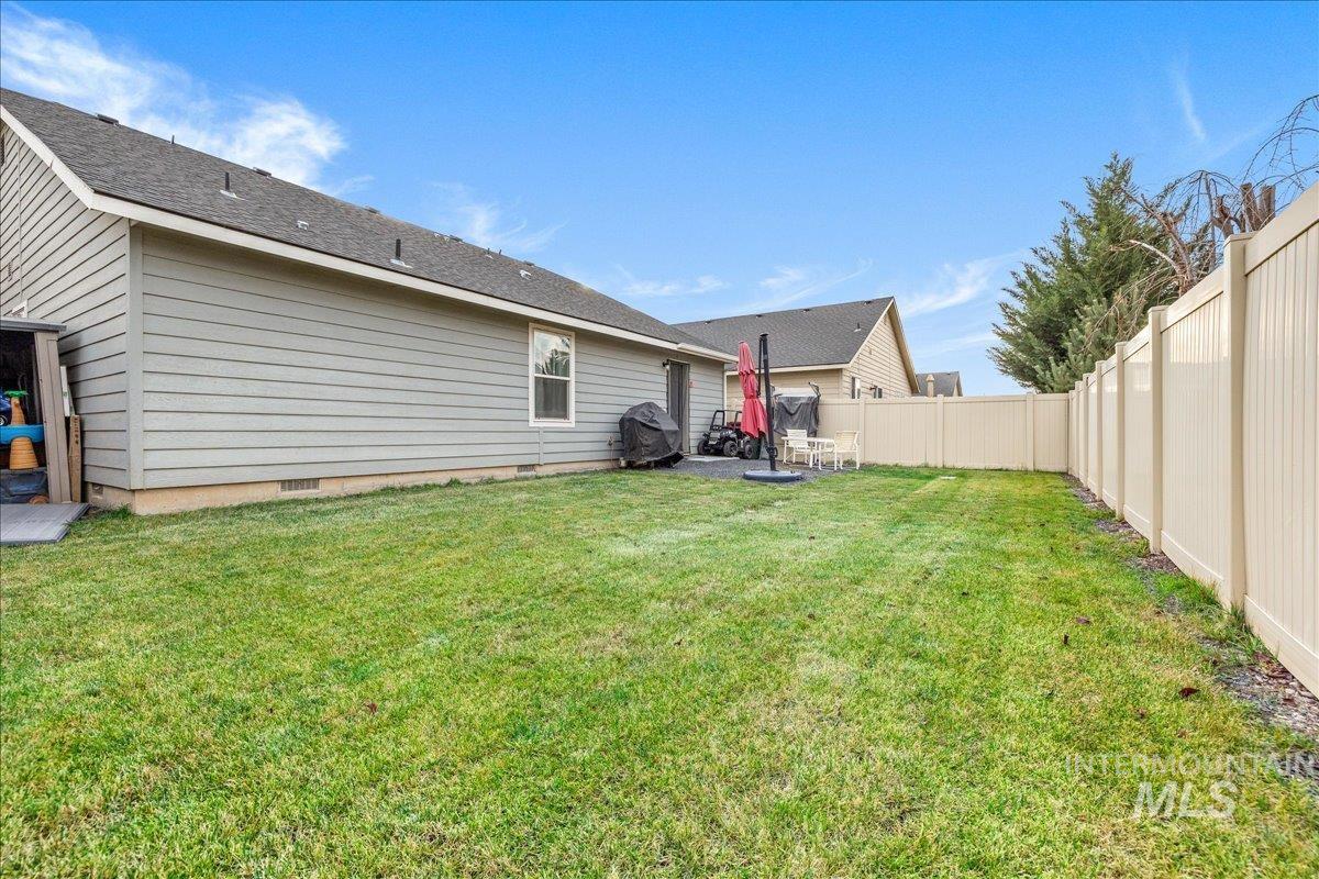 661 North Scotney Avenue Meridian, ID 83642 - Photo 19 of 22 Back of house with crawl space, a patio, a fenced backyard, and roof with shingles
