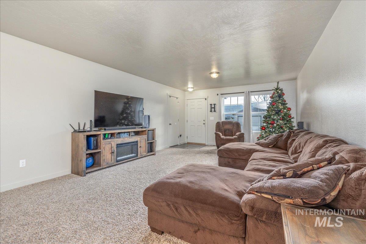 661 North Scotney Avenue Meridian, ID 83642 - Photo 5 of 22 Carpeted living room featuring a textured ceiling and baseboards