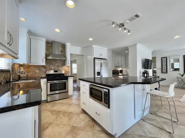 a kitchen with stainless steel appliances and white cabinets