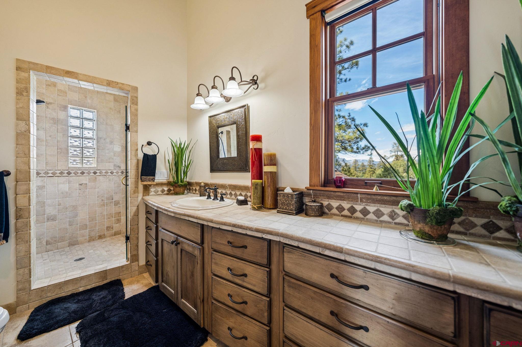 3623 Elkhorn Mountain Road Durango, CO 81301 - Photo 19 of 44 a spacious bathroom with a granite countertop sink a mirror and a shower