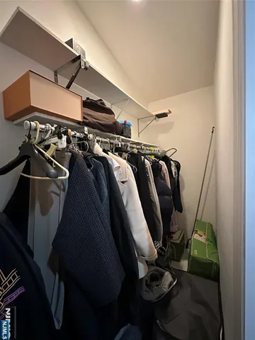 a view of walk in closet with clothes and shoes