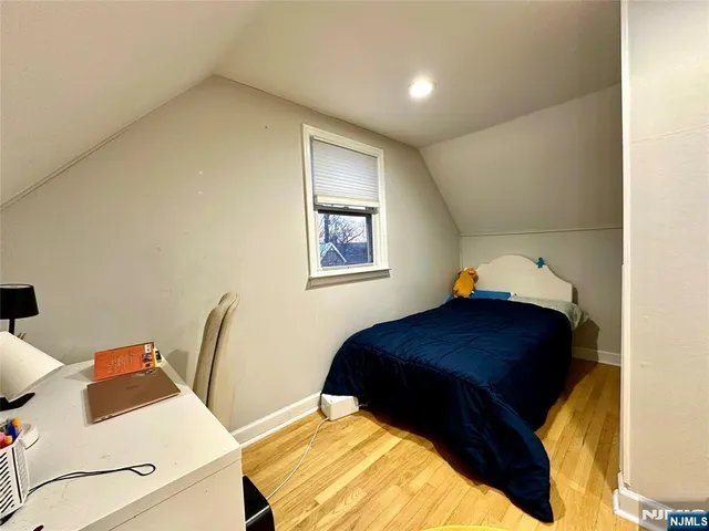 a bedroom with a bed and two windows