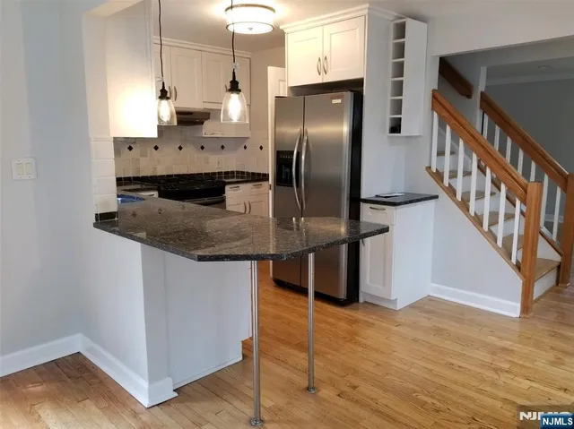 a kitchen with stainless steel appliances granite countertop a refrigerator a sink and a stove