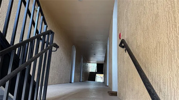 a view of a hallway with wooden floor and stairs