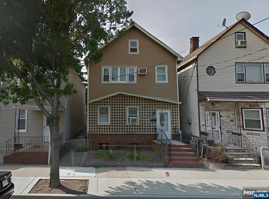 a front view of a house with a tree