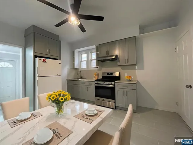 a kitchen with a stove a refrigerator and a dining table