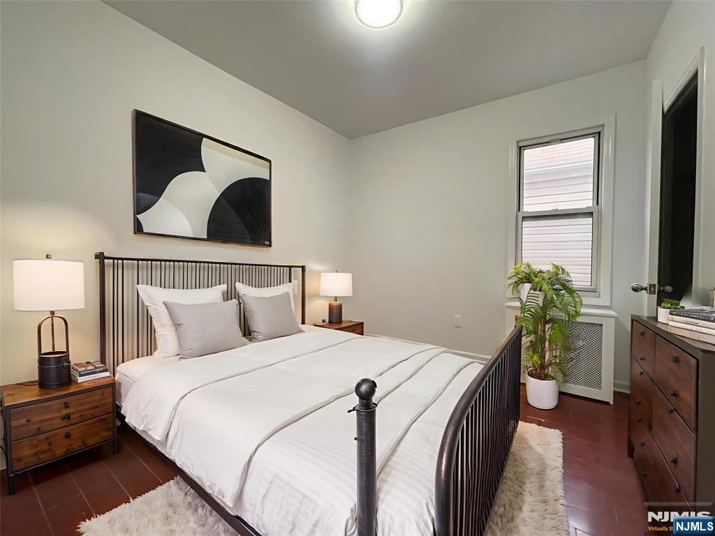 40 Searing Avenue, Unit 2 Harrison, NJ 07029 - Photo 6 of 11 a bedroom with a bed and a flat screen tv