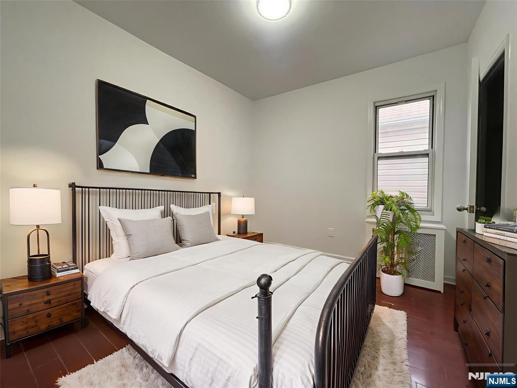 40 Searing Avenue, Unit 2 Harrison, NJ 07029 - Photo 6 of 10 a bedroom with a bed and a flat screen tv