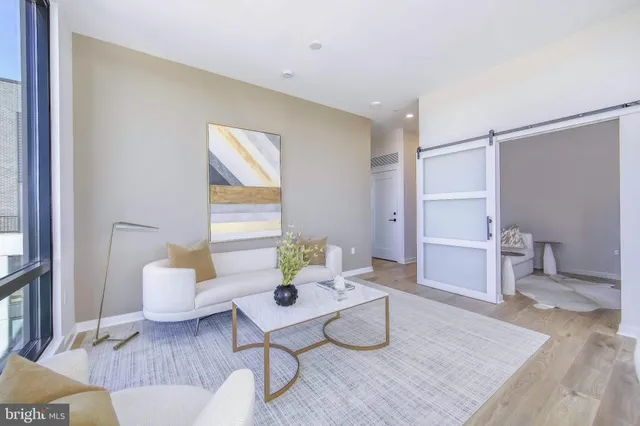 a living room with furniture and floor to ceiling windows