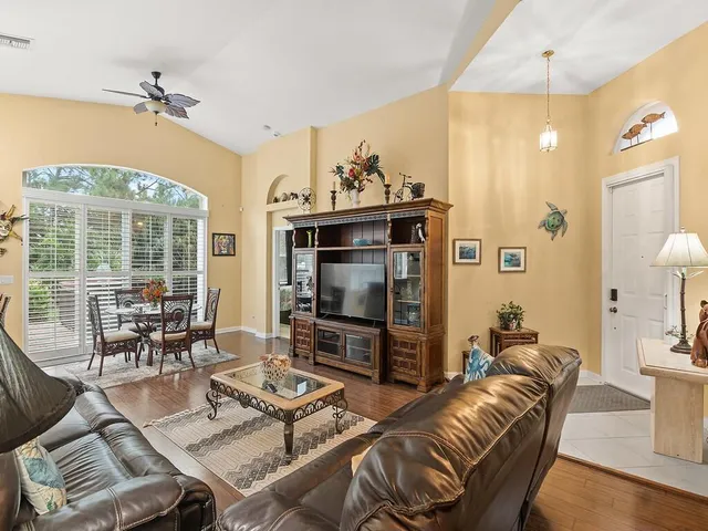 a living room with furniture a flat screen tv and a large window