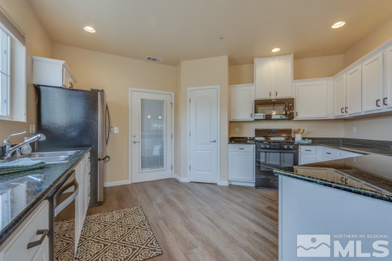 9050 Double R Boulevard, Unit 724 Reno, NV 89511 - Photo 4 of 18 a kitchen with a sink a counter top space stainless steel appliances and cabinets