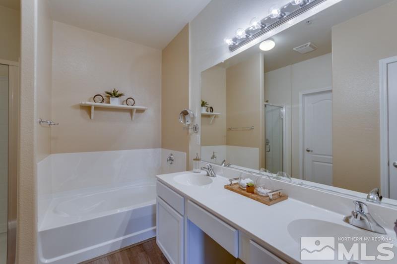 9050 Double R Boulevard, Unit 724 Reno, NV 89511 - Photo 8 of 18 a bathroom with a tub sink and mirror