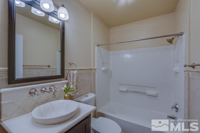 9050 Double R Boulevard, Unit 724 Reno, NV 89511 - Photo 10 of 18 a bathroom with a sink toilet a mirror and shower