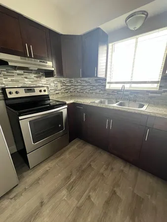a kitchen with granite countertop a sink and a stove